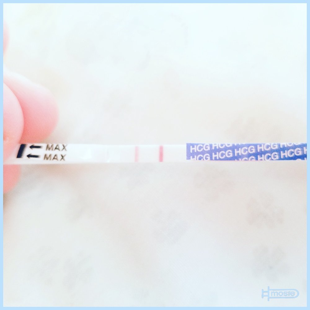 positive pregnancy test held by a mosie user